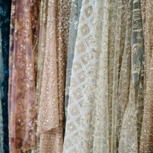 Close-up view of luxurious fabrics with intricate textures and shimmering details, ideal for fashion and design concepts.