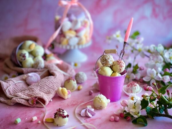 Pink-themed dessert setup with truffles, flowers, and pastel decorations for a spring celebration.