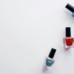 Three colorful nail polish bottles arranged creatively on a white backdrop, showcasing vibrant beauty products.