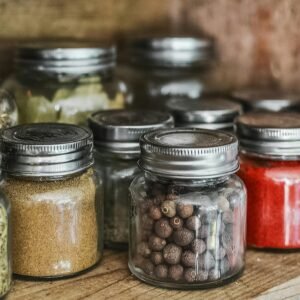 Close-up of assorted spice jars with various herbs on a kitchen shelf, showcasing colorful culinary ingredients.